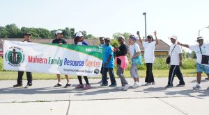 Volunteers holding up a MFRC banner.